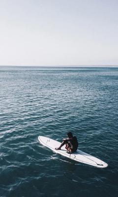 茫茫大海男人坐在冲浪板上手机壁纸