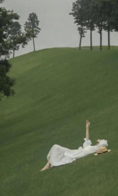 美女穿着白色公主裙躺在草坪半坡上手机壁纸