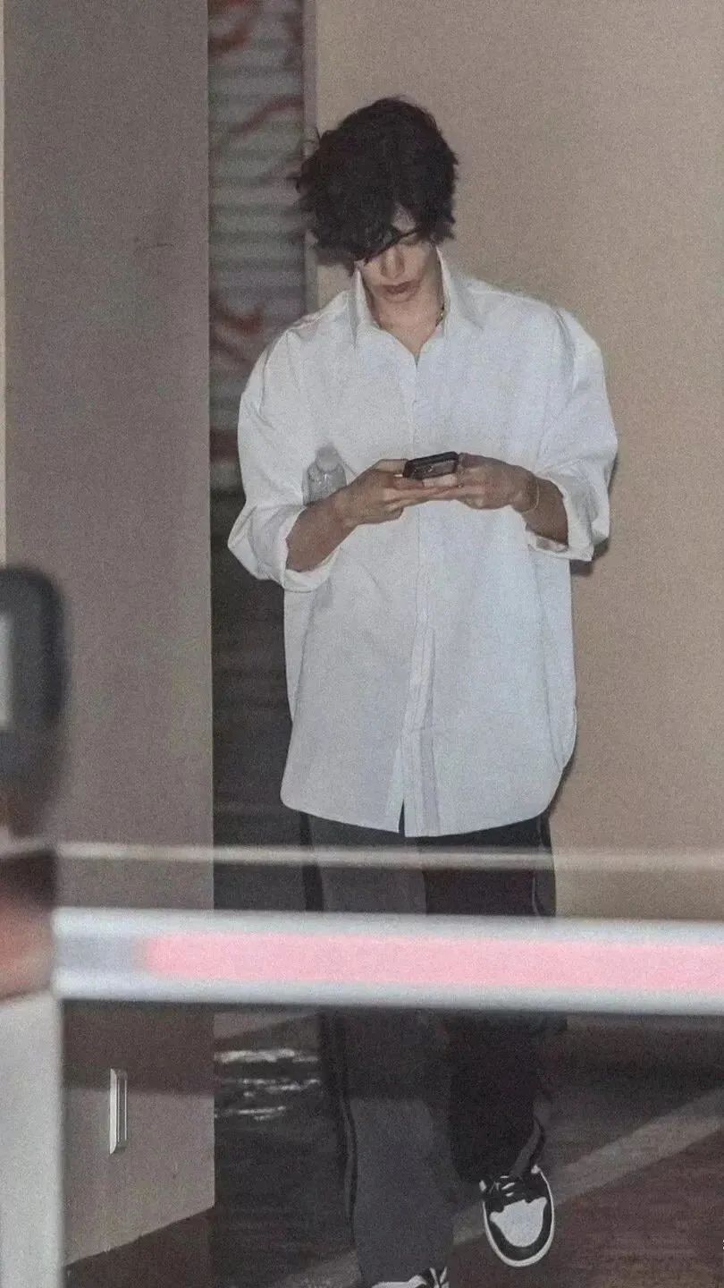 低头玩手机的白衬衫帅哥手机壁纸
