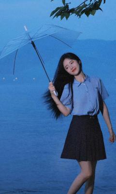 美女撑着透明伞站在海边手机壁纸