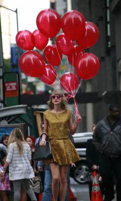 穿金色连衣裙拿红色气球的美女走在街头手机壁纸